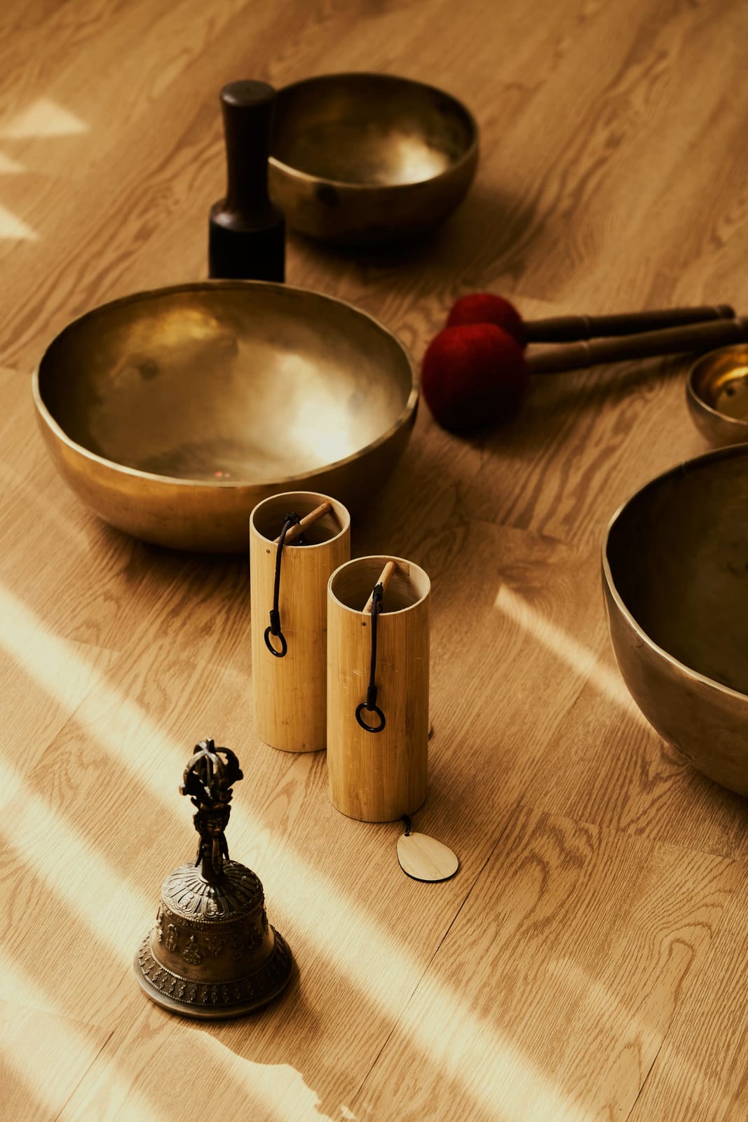 Singing bowls, chimes and a bell arranged on the studio floor before a sound bath at Hae Studio